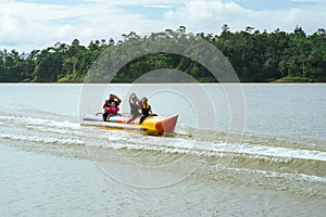 Family enjoying water activities on banana boat at the Kenyir Lake, Terengganu, Malaysia