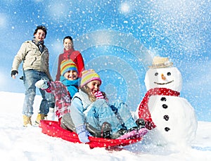 Family Enjoying Winter Day Tobogganing Concept