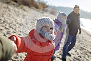 Family enjoying winter together, kids walking on the beach in winter, outdoors lifestyle