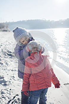 Family enjoying winter together, kids walking on the beach in winter, outdoors lifestyle