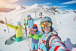 Family enjoying winter vacations in mountains . Ski, Sun, Snow and fun.