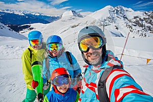 Family enjoying winter vacations in mountains . Ski, Sun, Snow and fun.