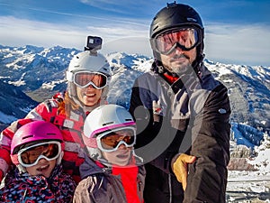 Family enjoying winter vacations taking selfie in skiing gear