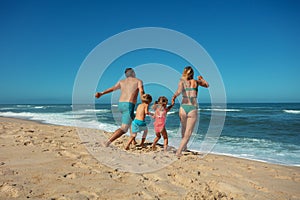 Family enjoys sunny beach day together walk along sandy seashore