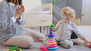 Family entertainment. Preschooler\'s learning journey. Developing creativity together. Cheerful woman playing with baby