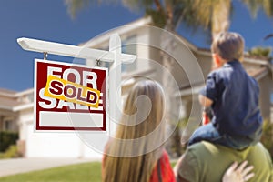 Family Facing Sold For Sale Real Estate Sign and House