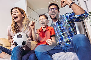 Family of fans watching a football match on TV