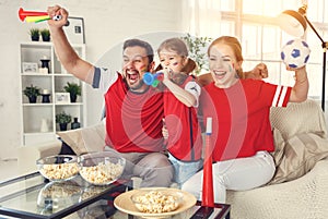 Family of fans watching a football match on TV at home