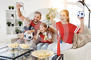 Family of fans watching a football match on TV at home