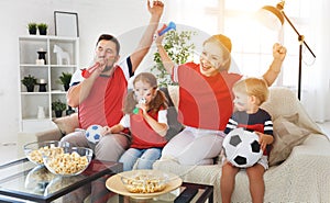 Family of fans watching a football match on TV at home