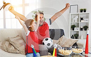 Family of fans watching a football match on TV at home