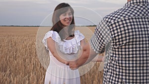 A family of farmers rejoices in wheat crop. Follow me, young happy couple running across golden wheat field. men and