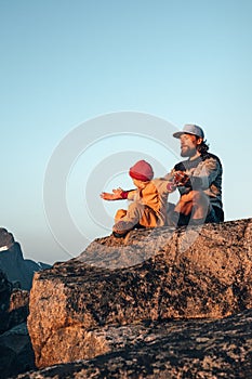 Family father and child outdoor practicing yoga in mountains healthy lifestyle vacations parent and kid training together