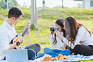 Family father, mother and child having fun and enjoying outdoor together sitting on the grass party with shooting photos