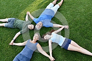 Family, father, mother, son and daughter lying in the meadow