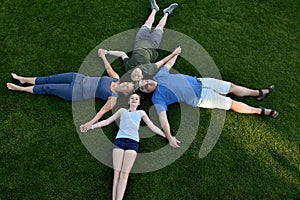 Family, father, mother, son and daughter lying in the meadow