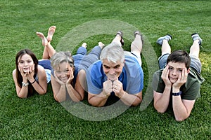 Family, father, mother, son and daughter lying in the meadow