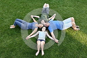 Family, father, mother, son and daughter lying in the meadow