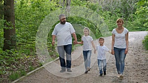 Family: father, mother, son and  daughter  walk in the Park in  white t-shirts . Family time concept