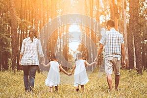 Family father, mother and two little child girls holding hand