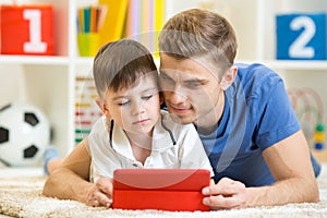 Family - father and son with tablet pc on floor at