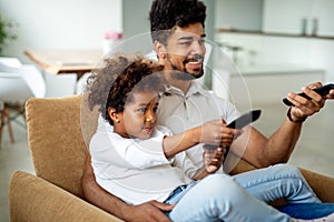 Family, fatherhood love people concept. Happy father and daughter watching tv at home