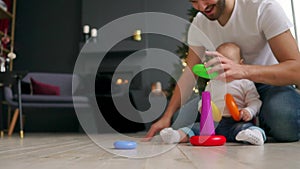 Family, fatherhood and people concept - happy father with little baby son playing with toys at home