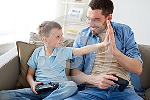 Father and son with gamepads doing high five