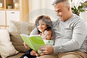 Happy father with sons reading book at home