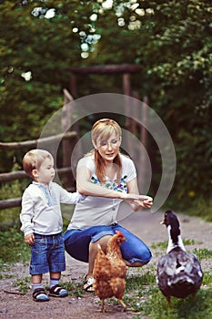 Family feeding chicken and duck on grassland