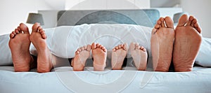 Family feet, bed and blanket in closeup, parents or kids sleeping on holiday in morning, care and relax. Bedroom, people