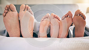 Family feet, bed and closeup with kid to relax with love, rest and sleeping on hotel mattress for vacation. Parents