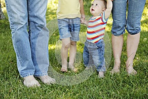 Family feet in jeans on the grass