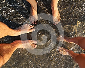 Family feet - mother, father and child at seaside