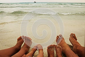 Family feet on the sand on the beach