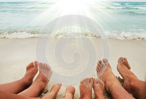 Family feet on the sand on the beach