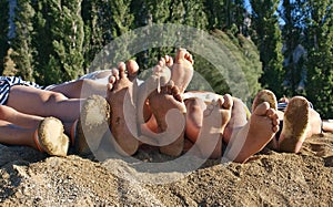 Family feet at the sandy beach