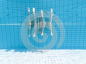 Family feet underwater in swimming pool