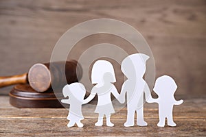 Family figure and judge gavel on wooden table. Family law concept