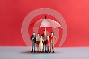 Family figurine under red umbrella, business concept Generative AI