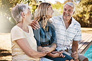 Family fills the days with sunshine. a happy young woman spending quality time with her elderly parents at the pool.