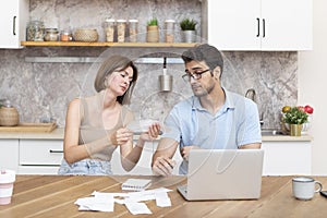 Family financial crisis concept. Shocked and stressed couple counting expenses, taxes and debts