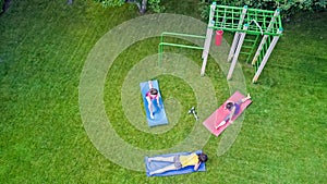 Family fitness and sport outdoors, group of active girls doing workout in park, aerial top view