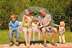 Family of five sit on bench