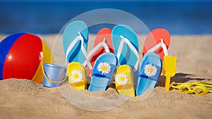 Family flip-flops, beach ball and snorkel on the sand. Summer vacation concept