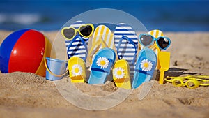 Family flip-flops, beach ball and snorkel on the sand. Summer vacation concept