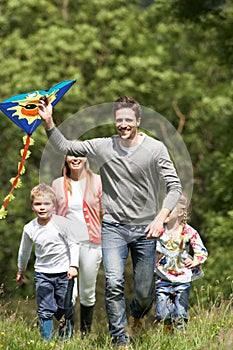 Family Flying Kite In Countryside