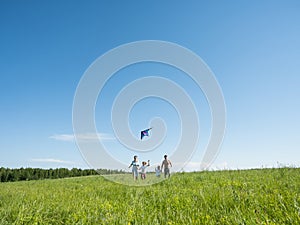 Family Flying Kite Together Outdoors