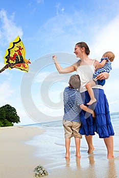 Family flying kite on tropical beach