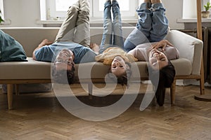 Family fooling around lying upside down on sofa